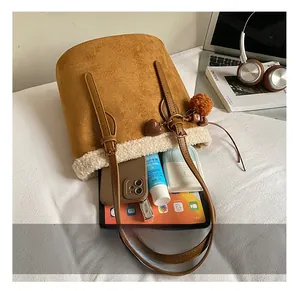 Brown suede bucket bag with faux shearling trim showing large interior storage space