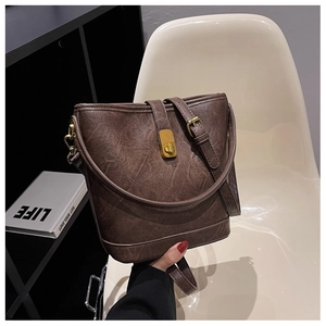 Detail of vintage brown leather bucket bag showing textured finish and golden lock