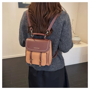 Detailansicht des Vintage-Rucksacks mit Kontrastfarben, Goldschnallen und Textdruck
