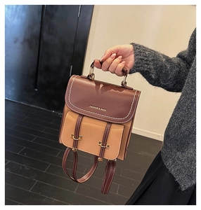 Detail eines kleinen Vintage-Rucksacks mit Kontrastnähten und Tragegriff