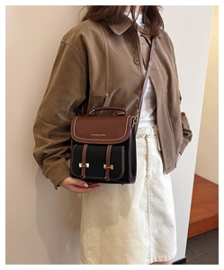 Details des Vintage-Rucksacks aus Kontrastleder mit weißen Nähten und goldener Schrift