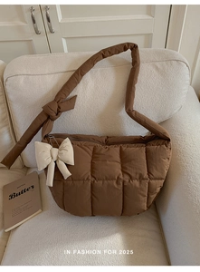Détail du sac à bandoulière matelassé marron orné d'un grand nœud blanc décoratif