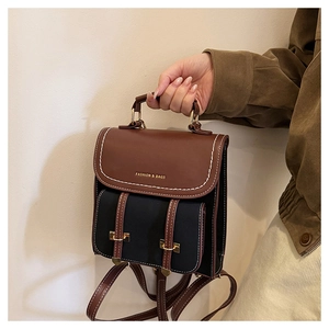 Detail des Vintage-Lederrucksacks mit Kontrastnähten und goldenen Metallbeschlägen