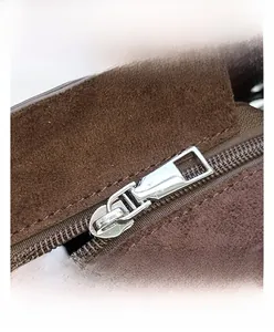 Gros plan d'un sac en daim marron avec fermeture éclair en métal argenté poli