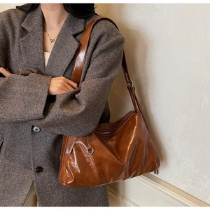 Macro shot of caramel brown faux leather shoulder bag texture with glossy oil-wax finish