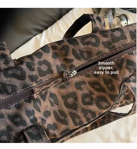 Close-up of high-quality smooth metal zipper and leopard print texture on canvas tote bag