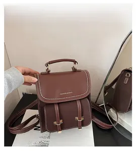 Makro-Detail des dunkelbraunen Lederrucksacks mit weißen Kontrastnähten und Schnalle
