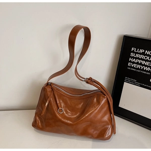 Detail of soft brown leather texture and metal zipper closure on the tote bag