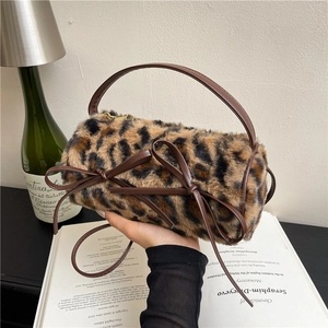 Faux fur leopard print cylinder handbag with leather bows and a golden zipper closure