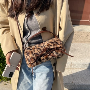 Faux fur leopard print cylinder crossbody bag with a brown leather bow detail