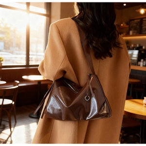 Detail of glossy deep brown tote bag with smooth texture and shiny mirror finish
