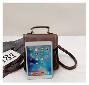 Brauner Vintage-Lederrucksack mit weißen Nähten, gezeigt mit Tablet zum Größenvergleich