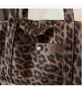 Detail shot of leopard print canvas tote featuring front pocket and metallic snap button