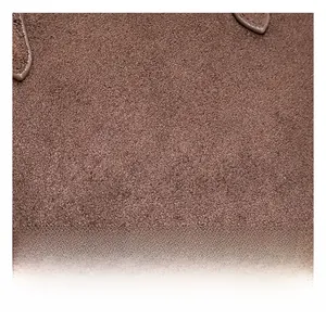 Gros plan sur la texture du daim marron montrant les fibres fines et la qualité du cuir