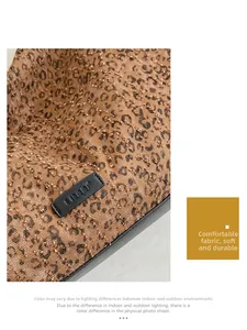 Macro detail of textured leopard print fabric and premium stitched leather brand tag