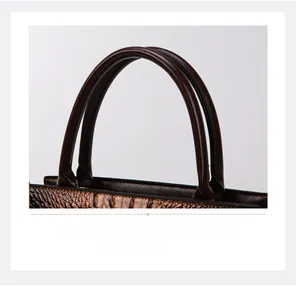 Makroaufnahme der feinen Nähte und Krokodilprägung auf der braunen Handtasche