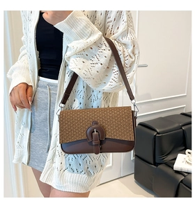 Détail du sac à bandoulière marron avec texture tissée et boucle décorative raffinée