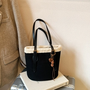 Retro black suede bucket bag with white faux fur trim and heart-shaped pendant accessory