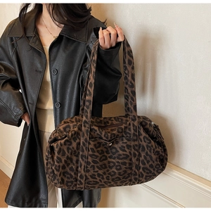 Detailed view of leopard print canvas tote bag with drawstring texture and metal zipper