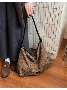 Detail of large leopard print hobo bag with sequin fabric and black shoulder strap