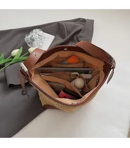 Vista interna della borsa tote intrecciata con dettagli in cuoio e chiusura magnetica