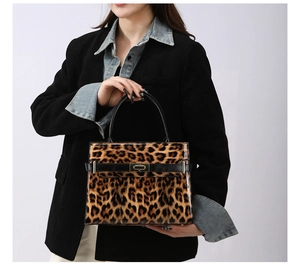 Detail der Leopard Handtasche mit glänzender Oberfläche und Metallverschluss