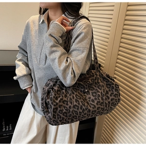 Detailed shoulder view of a large leopard print canvas tote bag with wide straps