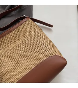 Dettaglio della borsa a spalla in paglia intrecciata con finiture in ecopelle marrone