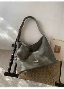Detail of vintage faux leather crossbody bag with contrast stitching and golden clasp