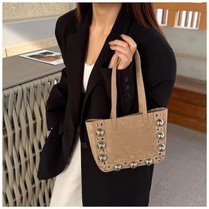 Détail du sac cabas en daim kaki avec des clous décoratifs en argent poli et œillets