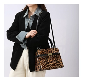 Detail der Handtasche mit Leopardenmuster, goldenem Schloss und strukturierten Griffen