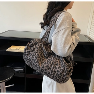 Model wearing high-capacity leopard print canvas bag as a casual shoulder tote bag