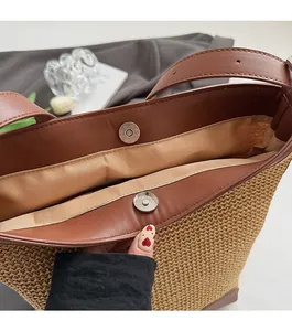 Dettaglio della borsa tote in paglia con chiusura magnetica e finiture in pelle