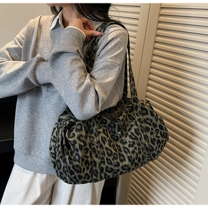 Leopard print canvas tote bag close-up showing texture and wide shoulder strap detail
