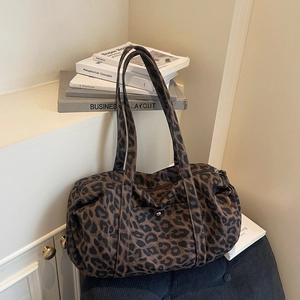 Detail of trendy leopard print canvas bag with long handles and top zipper closure