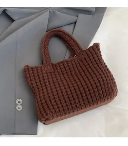 Detail shot of brown hand-woven crochet bag showing vertical stripe texture and handle