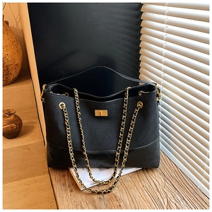 Detail of black quilted leather shoulder bag with gold twist lock and chain strap