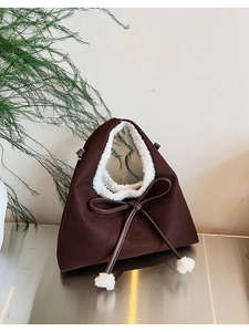 Détail du sac à bandoulière en suède avec bordure en fourrure et nœud décoratif