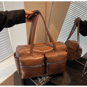 Macro detail of the dark brown PU leather texture and dual front zipper pockets