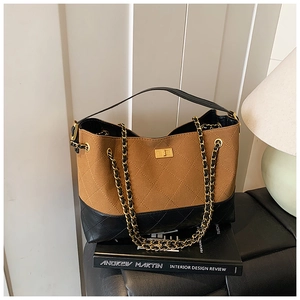Detail of two-tone quilted leather bag with frosted texture and gold chain strap