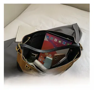 Detail view of large capacity two-tone shoulder bag showing spacious interior with chain strap