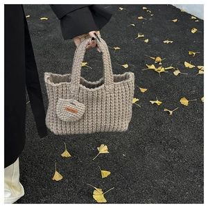 Detail of khaki crochet tote bag featuring handmade heart charm and ribbed texture