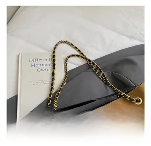 Detail of caramel suede crossbody bag with classic diamond quilting and gold chain strap