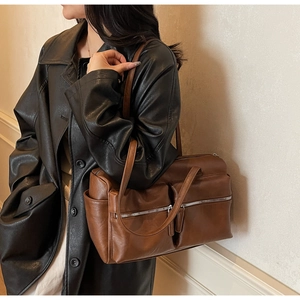 Detail of dark brown vintage faux leather tote bag with dual zipper front pockets
