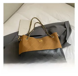 Detail of a brown quilted suede bag with gold twist lock and metal chain strap
