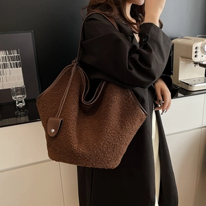 Close-up of deep brown sherpa fleece tote bag with premium leather handles for autumn style