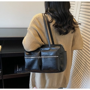 Detailed close-up of high-quality black PU leather texture and dual silver zipper pockets