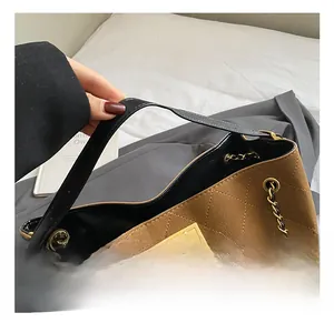 Detail of caramel frosted bag with diamond stitching, metal twist lock and chain strap