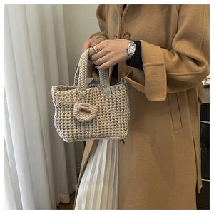 Detailed knit texture of beige crochet handbag with a heart-shaped handmade charm