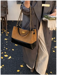 Detail of brown suede and black leather patchwork crossbody bag with chain strap